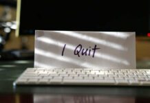 Envelope reading I Quit behind keyboard.