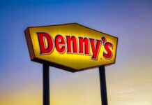 Denny's sign illuminated against a twilight sky