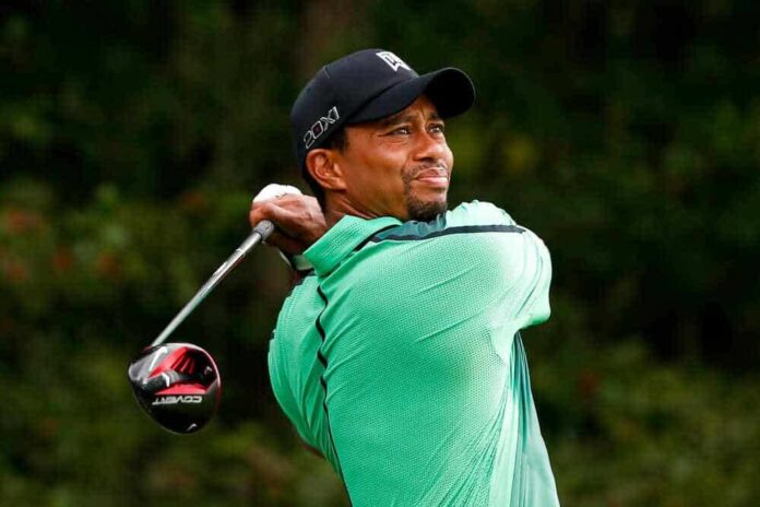 shutterstock_152723171-1.jpg featured image Tiger Woods mid-swing, wearing a green shirt and black cap.