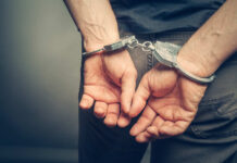 Person in handcuffs, hands behind their back.