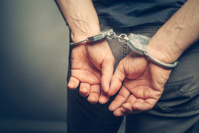 shutterstock_437224012-1.jpg featured image Person in handcuffs, hands behind their back.