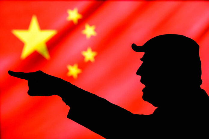 Donald Trump silhouette pointing with Chinese flag background