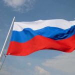 Russian flag waving against a cloudy sky.