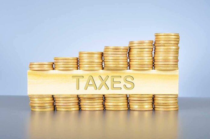 379014430 featured image Stacked coins with TAXES on block beneath.