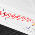 Document labeled restricted with pen signing signature line