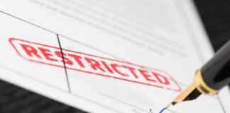 Document labeled restricted with pen signing signature line