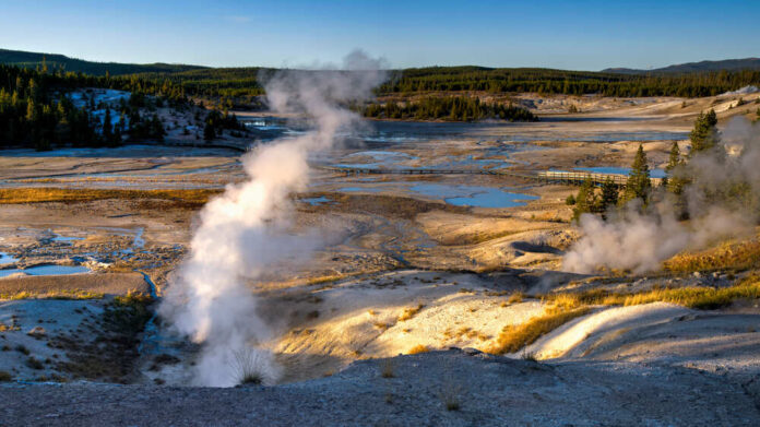 shutterstock_1666555798.jpg featured image Geysers emitting steam in Yellowstone National Park landscape