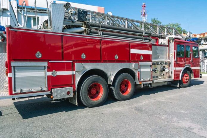shutterstock_2357242883.jpg featured image Red fire truck with ladder parked outside building