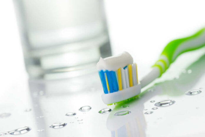 shutterstock_241865905.jpg featured image Toothbrush with toothpaste near glass of water