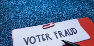 Paperclip holding paper labeled voter fraud marker
