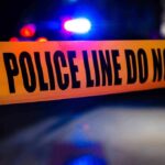 3 PEOPLE SHOT DEAD at Carnival – Including Infant! Police tape with flashing lights in the background.