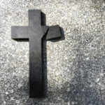 VIDEO: Gunman Attacks US Church Broken black cross on a gray surface.