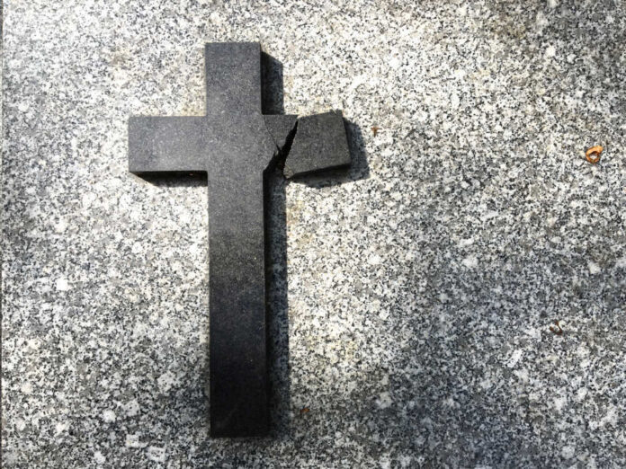 shutterstock_1119238859.jpg featured image Broken black cross on a gray surface.