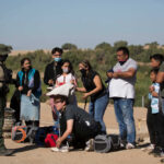 ICE Arrested 84 Illegals WHERE?! Group of people talking to border patrol officer.