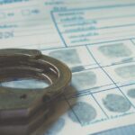 Handcuffs on a fingerprint document.