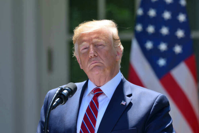 shutterstock_1432764869.jpg Donald Trump speaking with US flag in the back