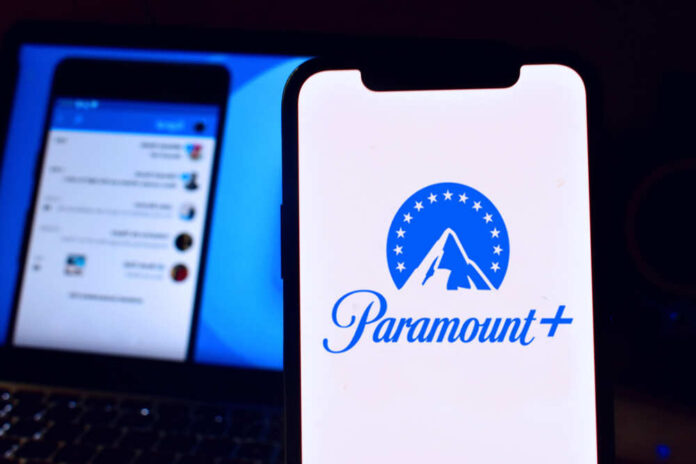 shutterstock_1943401627.jpg featured image Phone displaying Paramount Plus logo in front of laptop