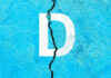 White letter D on cracked blue surface.