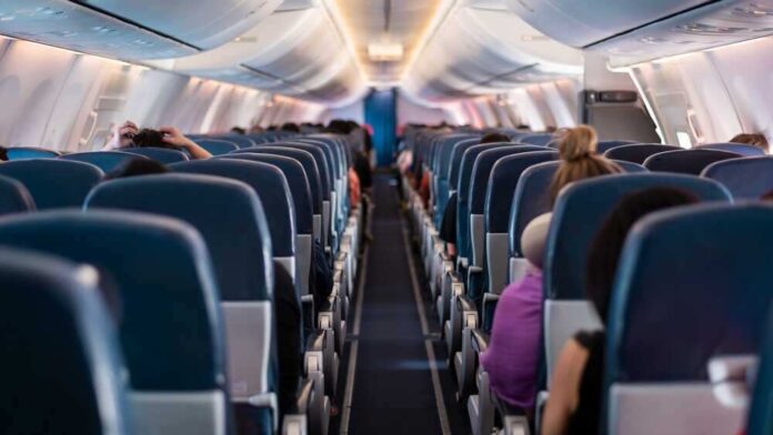 shutterstock_2292032849.jpg featured image Airplane interior with passengers seated mid-flight.