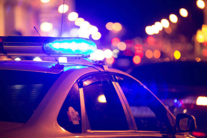 shutterstock_448997113.jpg Police car with blue lights flashing at night