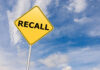 Yellow sign with RECALL text against blue sky