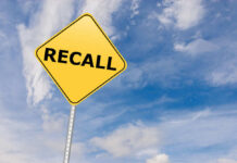 Yellow sign with RECALL text against blue sky