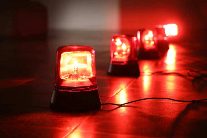 shutterstock_1042134532.jpg Red emergency lights on dark floor illuminating the area