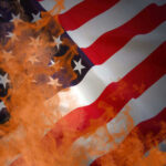 American flag partially set on fire with orange flames