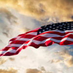 Staggering 97% Migration Drop Stuns Critics American flag waving against a cloudy sky