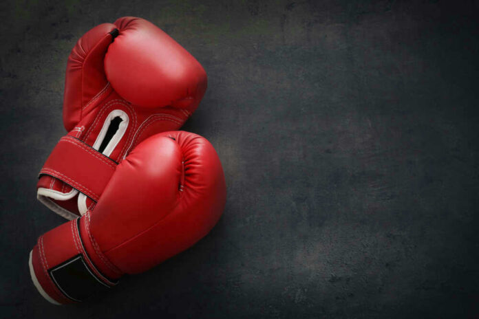 Red boxing gloves on a dark, textured surface
