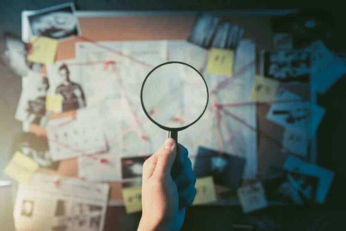shutterstock_1192132651-1.jpg Magnifying glass over investigation board with photos and strings