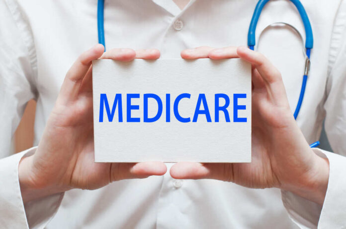 A medical professional holding a sign that says MEDICARE