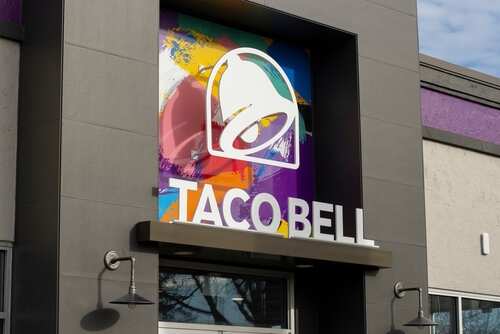 Exterior view of a Taco Bell restaurant with colorful mural