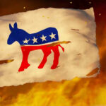 Torn Democrat flag burning amid flames and embers