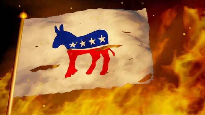 Torn Democrat flag burning amid flames and embers