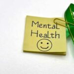 Sticky note with Mental Health written on it and a green ribbon