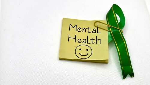 shutterstock_2627724619.jpg Sticky note with Mental Health written on it and a green ribbon