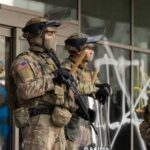 Trump’s National Guard Plan: Next City Announced Military personnel in tactical gear standing guard during a protest