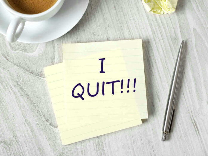 Note with I QUIT near coffee, pen, paper ball