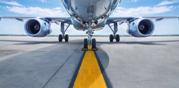 Airplane on runway with visible landing gear engines