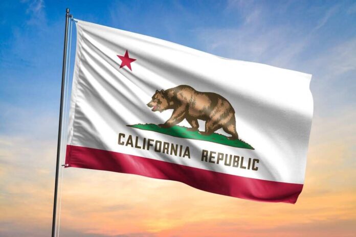 California state flag waving against a sunset sky