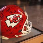 A signed Kansas City Chiefs football helmet displayed in a case