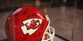 A signed Kansas City Chiefs football helmet displayed in a case