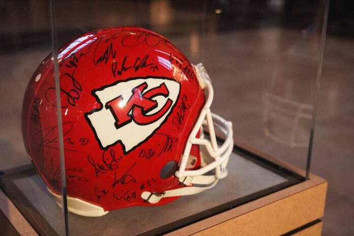 A signed Kansas City Chiefs football helmet displayed in a case