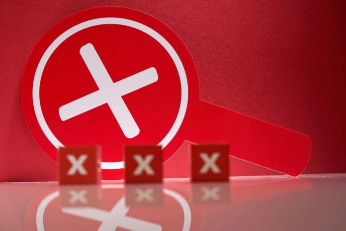 A red magnifying glass with a cross symbol against a red background