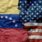 Trump Tells Venezuelans To Go Home Crumpled flags of Venezuela and the United States split in the center