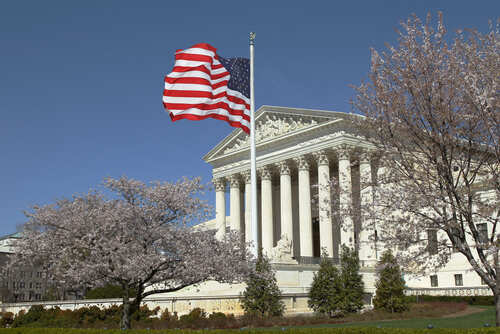 shutterstock_270314606.jpg U.S. Supreme Court building with an American flag and cherry blossom trees