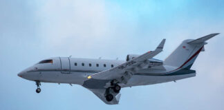 A private jet approaching for landing against a cloudy sky