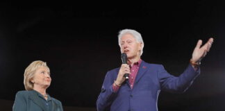 Hillary Clinton and Bill Clinton speaking at a political rally