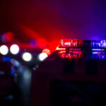 HORROR at Parade: Five Shot Down Police car lights shining in the dark.
